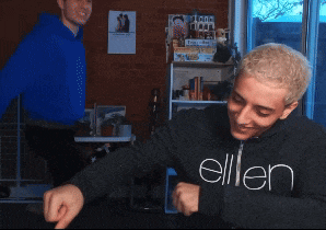 a man wearing a black allen sweatshirt stands in a room