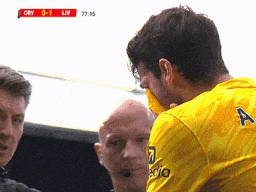 a man wearing a yellow jersey with the letter a on the back