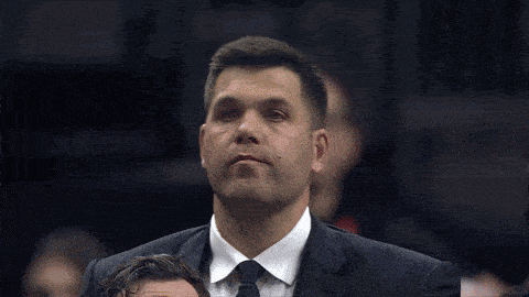 a man in a suit and tie looks to his left