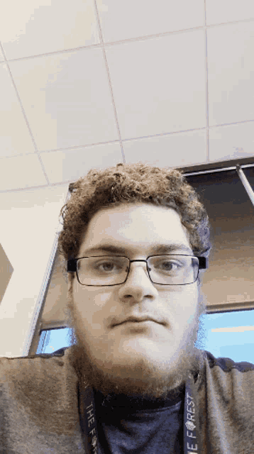 a man with glasses and a lanyard that says " the forest "