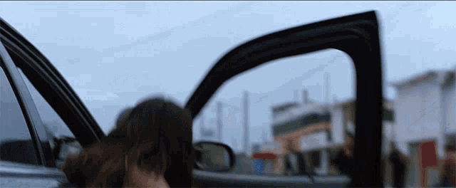 a woman is getting out of a car with her door open