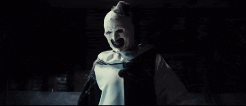 a clown with his arms outstretched is wearing a black and white costume