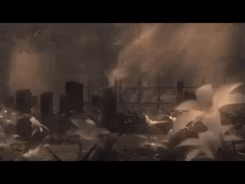 a group of people are standing in front of a destroyed city in a movie scene .