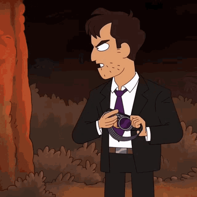a man in a suit and tie holds a camera