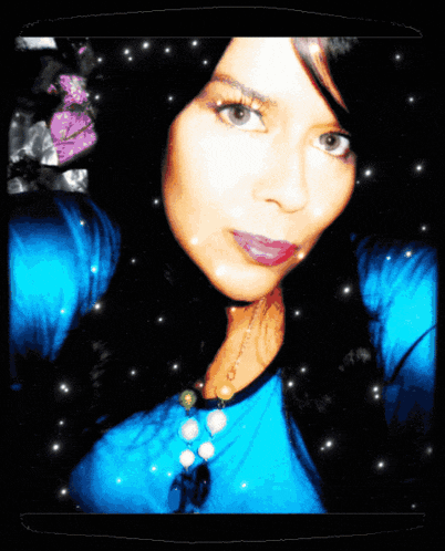 a woman in a blue shirt is surrounded by sparkles