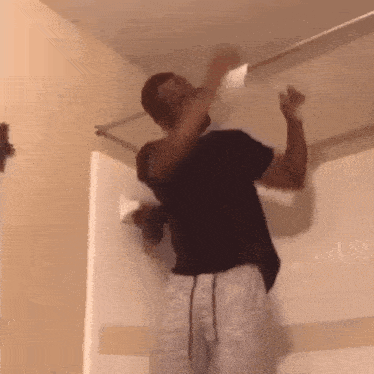 a man is standing in a bathroom holding a piece of toilet paper in his mouth .