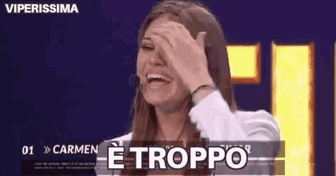 a woman is laughing and covering her face with her hand and the words e troppo are above her