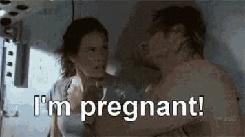 a man and a woman are looking at each other and the woman is pregnant .