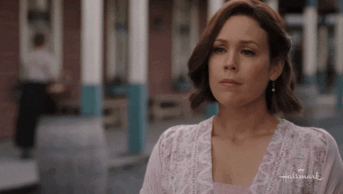 a woman is wearing a pink shirt with the word hallmark on it