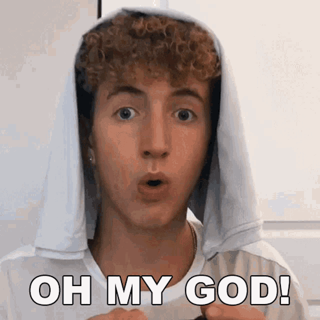 a young man with a towel on his head is saying oh my god !