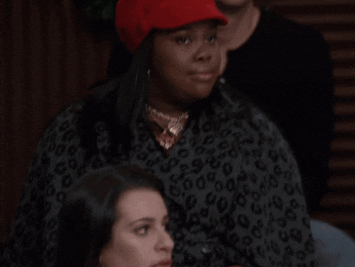 a woman wearing a red hat and leopard print sweater
