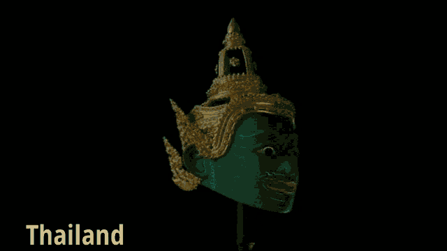 a green and gold mask with the word thailand written below it