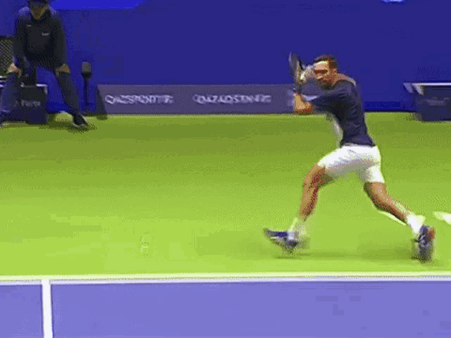 a tennis player is swinging a racket on a court with a sign that says gazaosener on it