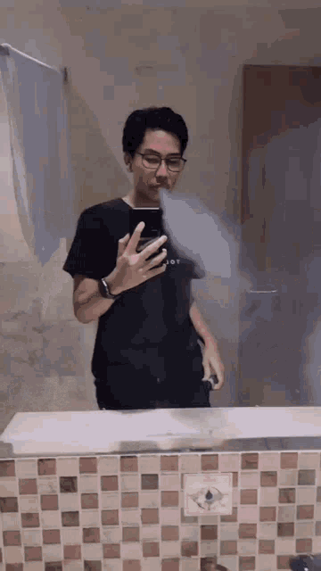 a man taking a picture of himself in a bathroom mirror with smoke coming out of his mouth