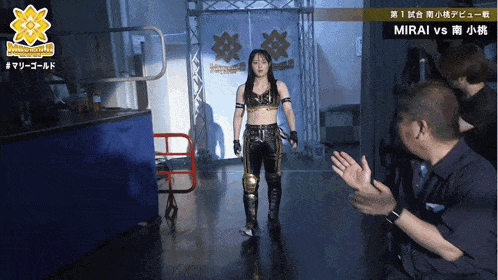 a woman walking down a hallway with a sign that says mirai vs on it