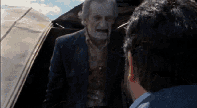 a man in a suit talking to another man