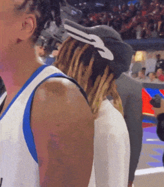 a man with dreadlocks is wearing a hat with a nike logo on it