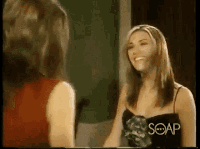 two women are standing next to each other and one of them is wearing a black top that says soap