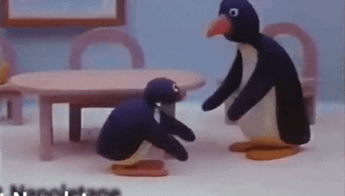 a couple of stuffed penguins are standing next to each other in a room .