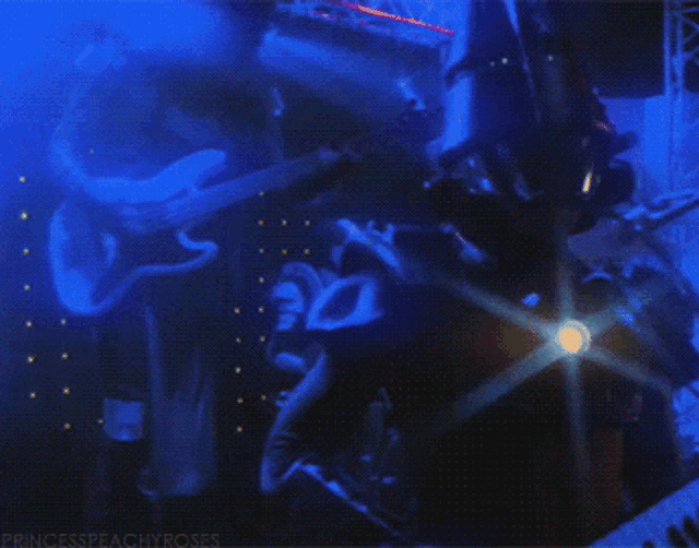 a man in a top hat stands in a dark room with the words princesspeachyroses on the bottom right