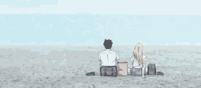 a man and a woman sit on a beach looking at the ocean