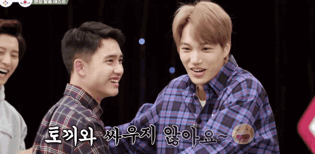 a man in a plaid shirt hugs another man in a plaid shirt