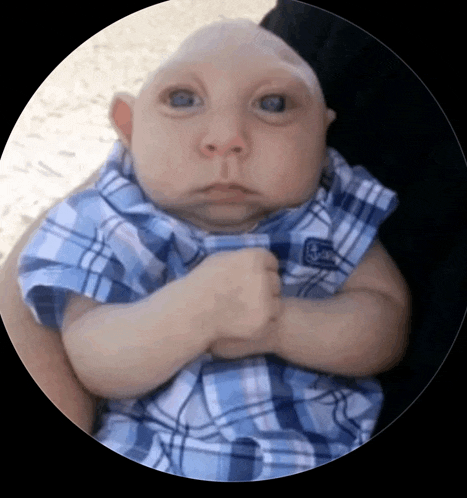 a baby wearing a blue plaid shirt with a s on the sleeve