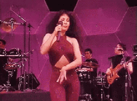 a woman is dancing on a stage in front of a microphone .