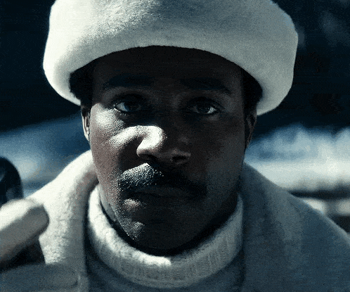 a man wearing a white fur hat and a white sweater