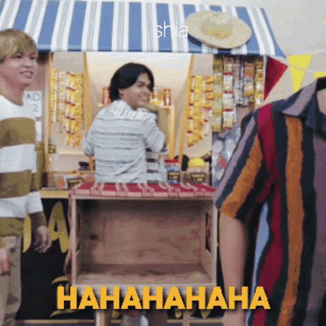 a man in a striped shirt is standing in front of a sign that says ' hahahaha '