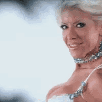 a woman wearing a choker and a bra is smiling .
