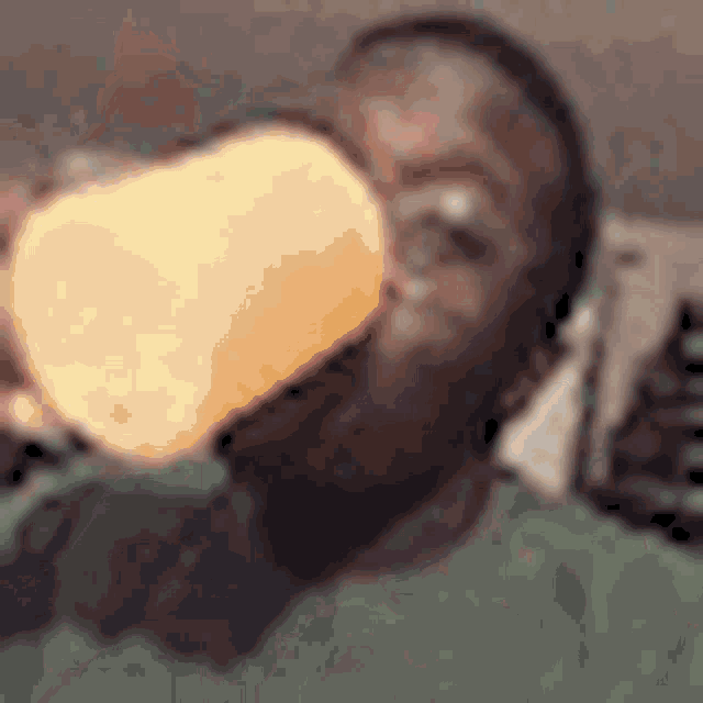 a man in a green shirt is drinking from a cup .