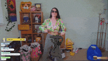 a woman in a floral top is dancing in a room with a spongebob drawing on the floor