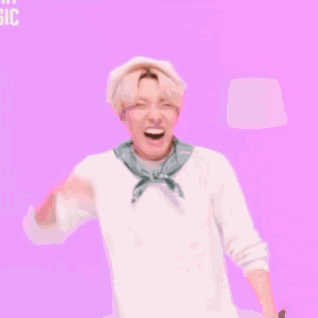 a man wearing a hat and a scarf is laughing .
