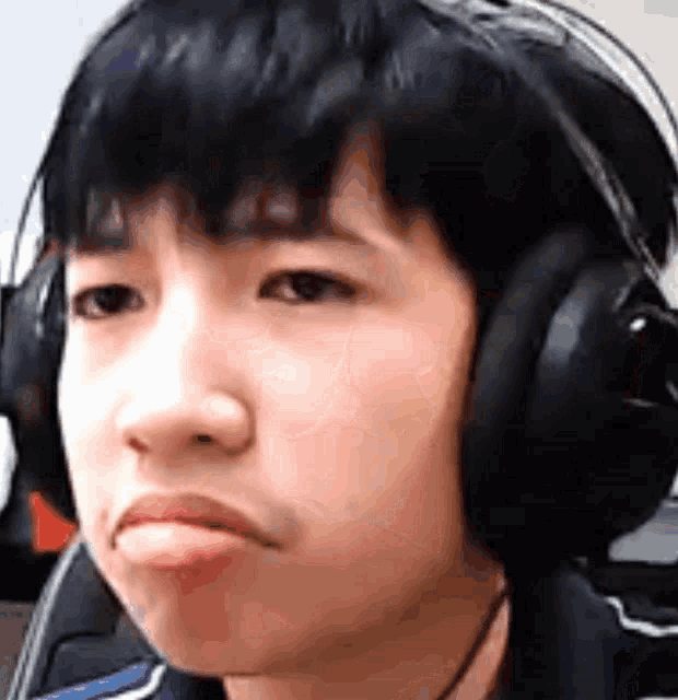 a young boy wearing headphones is making a face .