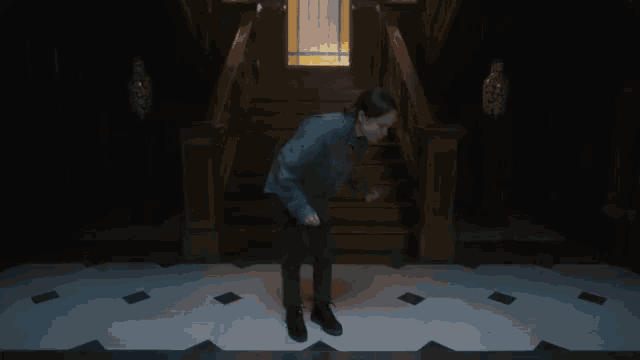 a man is dancing in front of a set of stairs .