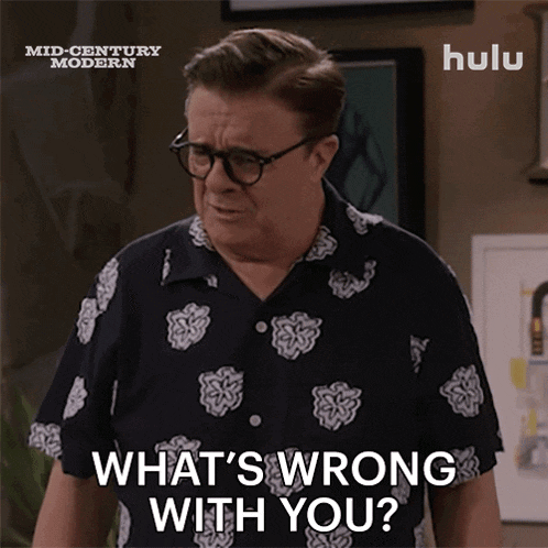 a man wearing glasses and a shirt says what 's wrong with you