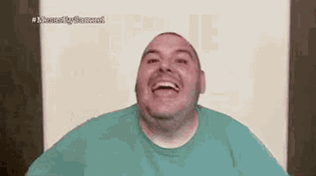 a man in a green shirt is laughing .