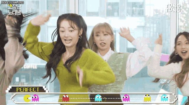 a group of girls are dancing in front of a perfect sign