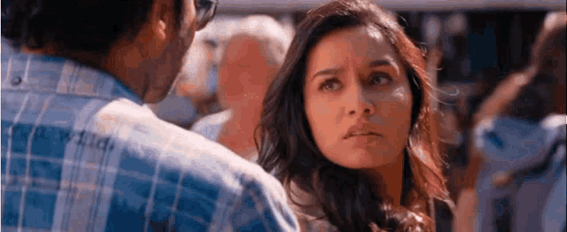 a man and a woman are looking at each other in a crowd of people .