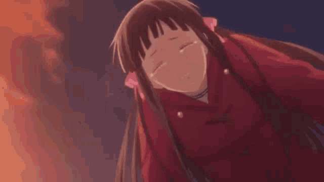 a girl in a red jacket is crying and smiling .