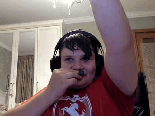 a boy wearing headphones and a red shirt with a ferrari logo on it