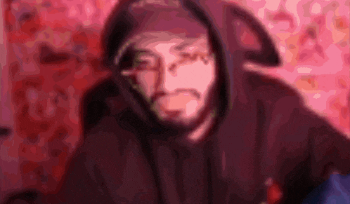 a blurry picture of a man wearing a hoodie and hat