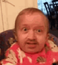 a baby with a fake mustache is sitting in a high chair .