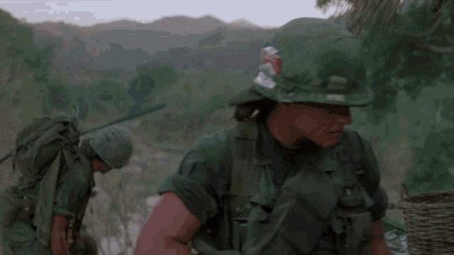 a soldier with a can of marlboro on his helmet is walking