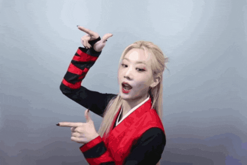 a woman in a red and black jacket is pointing