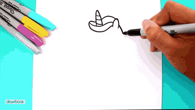 a person is drawing a unicorn on a piece of paper with sharpie markers