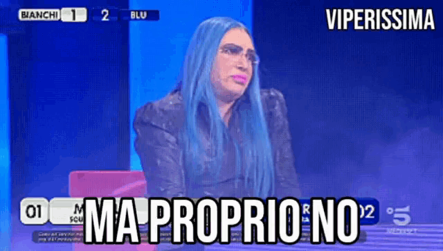 a woman with blue hair and glasses is sitting in front of a blue screen that says viperissima