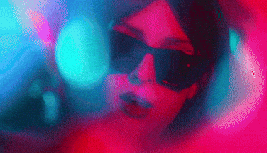 a woman wearing sunglasses and a virtual reality headset is looking at the camera .