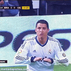 a man in a white adidas jersey stands in front of a sign that says rma 3-0 cel